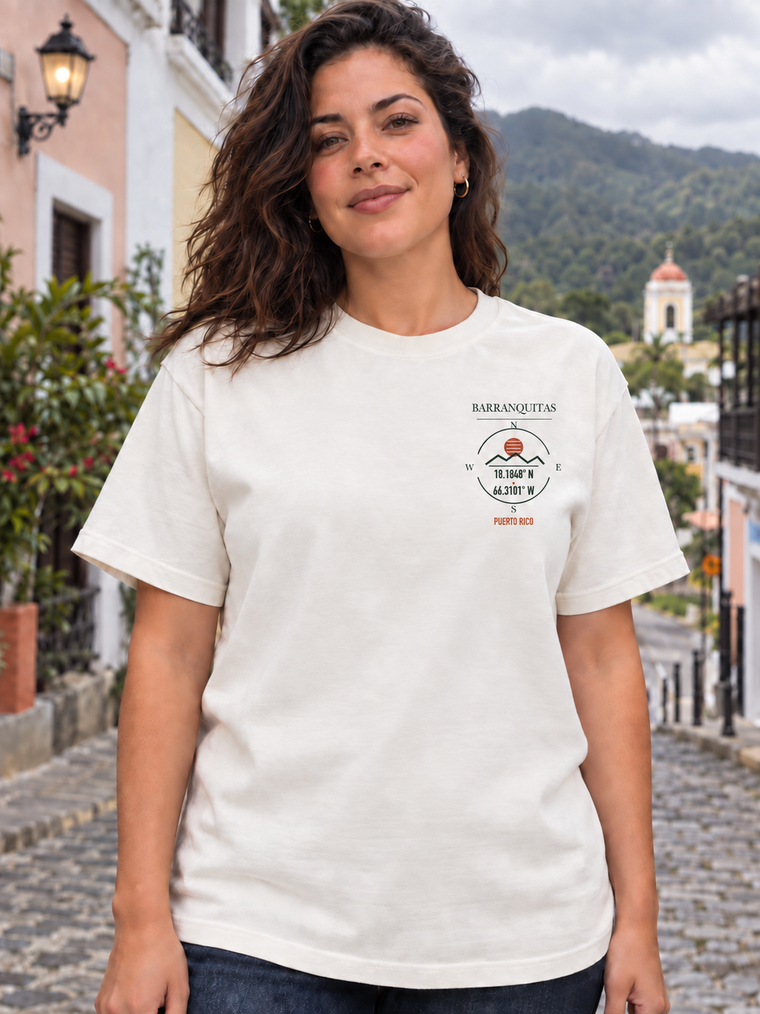 AI-generated styling visualization: woman wearing the ivory Barranquitas tee, showing the small corrected left-chest emblem.